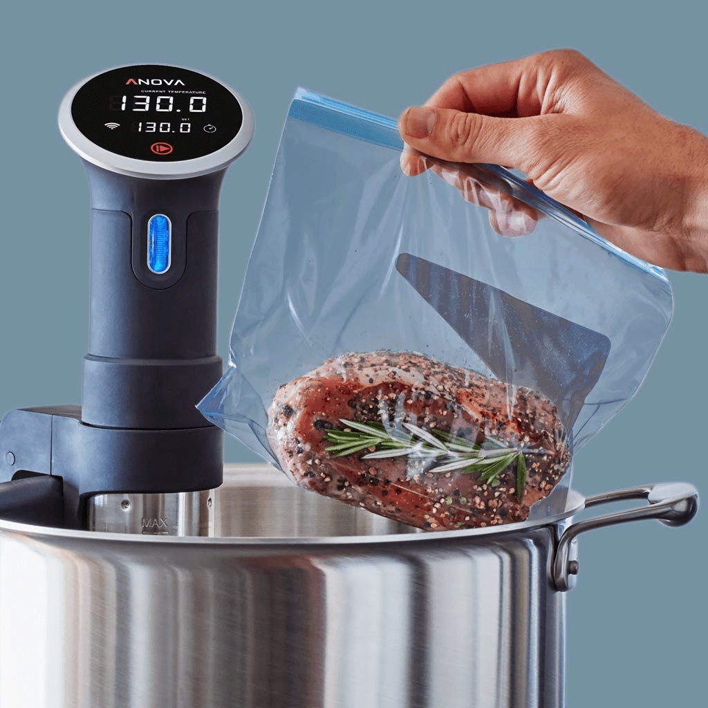 A vacuumed bag with steak is placed in a pot of water with a Sous Vide cooker inside
