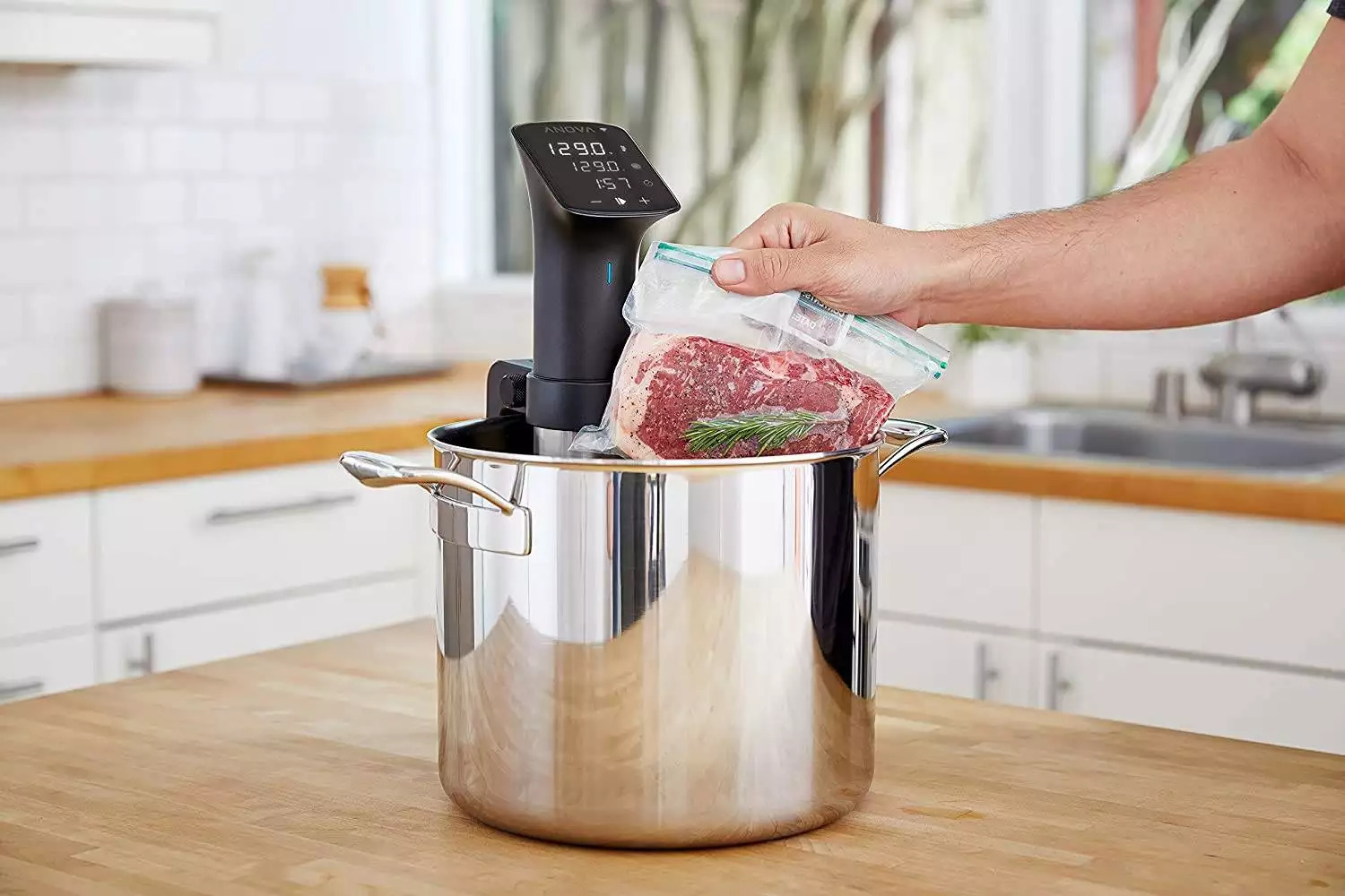 Another vacuumed bag with steak is placed in a different pot of water with a Sous Vide cooker inside